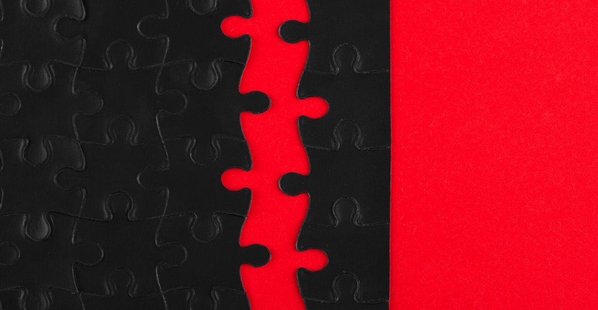 A black jigsaw puzzle split down the middle on a red background — the gap between client and designer when you don't brief a designer clearly